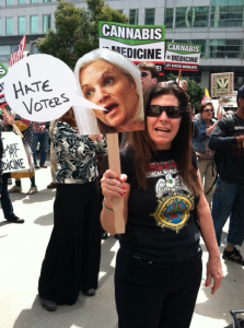 Activist Mikki Norris holds a mask of US Attorney Melinda Haag's face in front of Haag's office in San Francisco.
